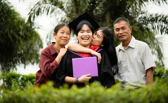 大学毕业生微笑着拿着毕业证书和家人一起庆祝